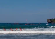Semangat Perempuan Pengibar Bendera Merah Putih di Tengah Ombak Pantai Baron