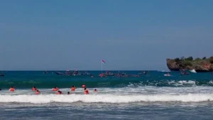 Semangat Perempuan Pengibar Bendera Merah Putih di Tengah Ombak Pantai Baron